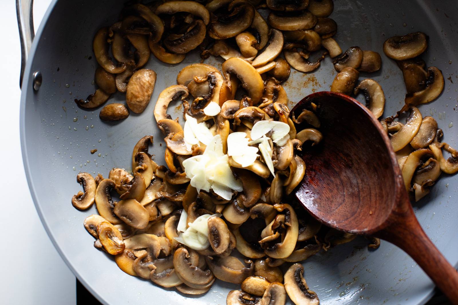 sautéing蘑菇和大蒜非扁锅